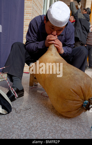 Salar l'homme de l'air dans la peau de mouton pour faire un radeau, Salar Xunhua comté autonome, la Préfecture de Haidong, Qinghai, Chine Banque D'Images