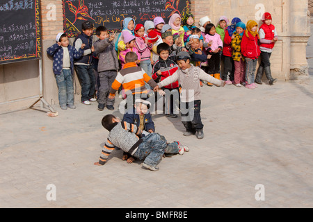 Salar enfants jouant dans l'école islamique locale, Xunhua Salar comté autonome, Haidong préfecture, province de Qinghai, Chine Banque D'Images