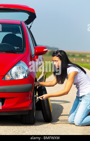 Jeune femme avec un pneu de voiture à ventilation Banque D'Images