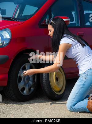 Jeune femme avec un pneu de voiture à ventilation Banque D'Images