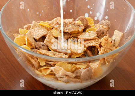 Verser le lait sur les flocons de maïs bol. Banque D'Images