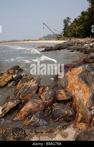 L'Inde, le Kerala, Mahe (Pondichéry) Territoire de l'Union, vieille Grue de rouille sur les défenses côtières de brise-lames rocheuses Banque D'Images
