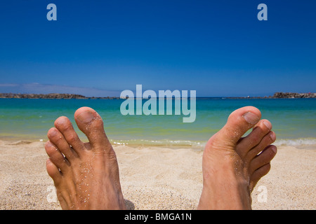 Men's feet on the beach on a sunny day Banque D'Images