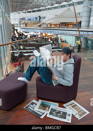 Un élève lit un journal sur l'aéroport de Stockholm-Arlanda. Banque D'Images