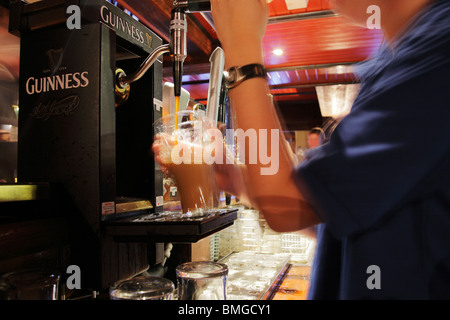 Barman de servir un verre de Guinness dans la King's Bar à Clifden, Irlande Banque D'Images