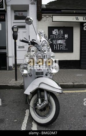 Un Vespa scooter festonné avec des lumières en stationnement sur un compteur bay Banque D'Images