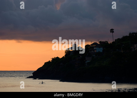 Comme le soleil se lève sur Amed, Bali, des pêcheurs dans leurs petites embarcations appelées jukung retour à terre pour décharger leurs prises de la journée. Banque D'Images