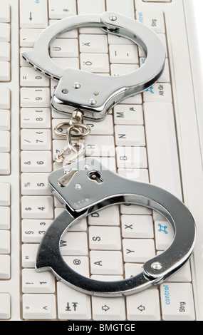 Un clavier d'ordinateur et des menottes. La cybercriminalité. Banque D'Images