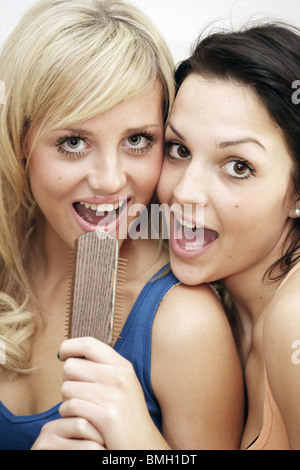 Teenage Girls singing into hairbrush modèle publié. Banque D'Images