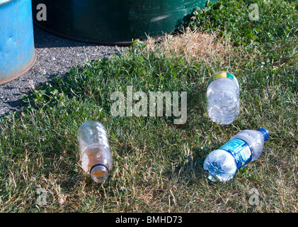 Trois bouteilles d'eau en plastique jetés sur le terrain. Les déchets et détritus pas vert. Banque D'Images