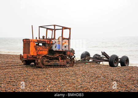 Bateau de pêche côtière et Caterpillar Tractor trailer sur la plage de galets à Weybourne, Norfolk, Angleterre. Banque D'Images