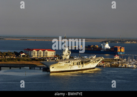 Porte-conteneurs passant le USS Yorktown avec Morris Island Lighthouse dans la Distance près de Charleston, Caroline du Sud Banque D'Images