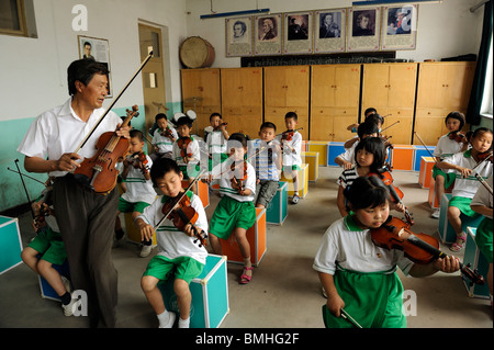 M. Gao Defa enseigner aux élèves à jouer du violon pendant une leçon de musique à l'école primaire en Dawangwu Pinggu, Beijing, Chine. 2010 Banque D'Images