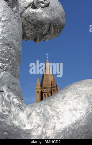 Volare par Lorenzo Quinn, situé dans la région de Brown Hart Gardens donnant l'impression d'une vue sur l'église dans la distance. Banque D'Images