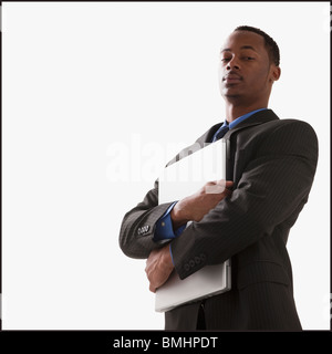 Serious businessman holding a laptop computer Banque D'Images