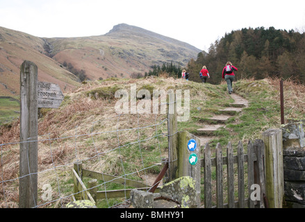 Un panneau et les Randonneurs sur un sentier menant à Helvellyn près de Thirlmere Lake District, Cumbria, England, UK Banque D'Images