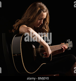 Young woman playing guitar Banque D'Images