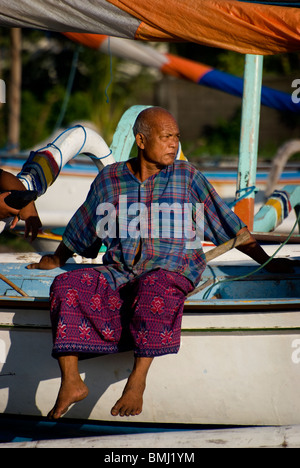 Un pêcheur balinais se repose après une longue nuit de la pêche dans son petit voilier outrigger appelé un jukung. Village d'AMED. Banque D'Images