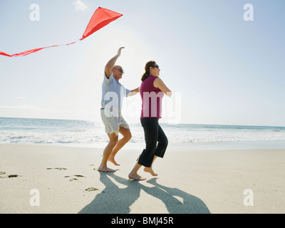 Couple flying kite on beach Banque D'Images