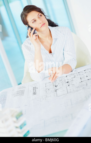 Woman looking at blueprints Banque D'Images