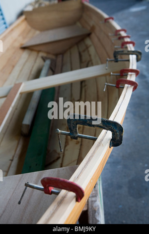 Carpenter presses dans le chantier, maintenant l'ensemble le côté bandes d'une godille, Auckland, Nouvelle-Zélande Banque D'Images