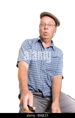 Vieil homme expressif de l'interrupteur à distance d'exploitation isolés contre fond blanc.