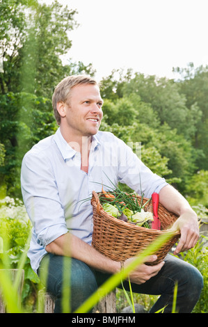 Homme assis avec panier Banque D'Images