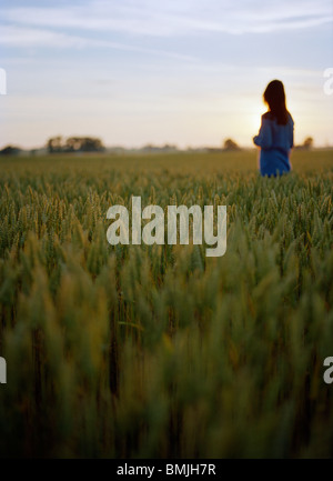 Mid adult woman standing dans les champs Banque D'Images