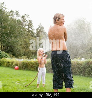 Pulvériser de l'eau sur frère soeur Banque D'Images