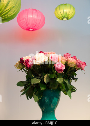 Lampes de plafond rose et vert et roses dans un vase, en Suède. Banque D'Images