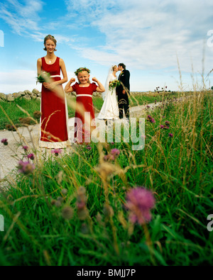 La Scandinavie, la Suède, l'Oland, fille de fleur et de demoiselle avec Bride and Groom kissing en arrière-plan Banque D'Images