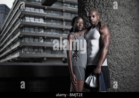 Portrait de l'homme et la femme athlétique habillé en sportswear sur City Housing Estate Banque D'Images