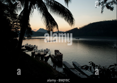 Les soleils se couche derrière les montagnes sur le Mékong à Luang Prabang au Laos Banque D'Images