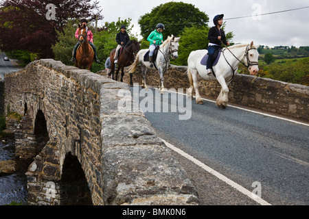 Les randonneurs à cheval traversant le pont à Postbridge, Dartmoor National Park, Devon, Angleterre Banque D'Images