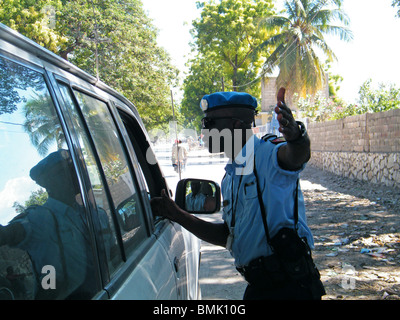 Un policier arrête un chauffeur à un barrage routier à la périphérie de Gonaïves, Haïti Banque D'Images