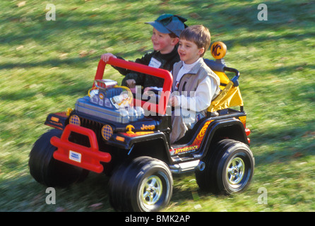 2, 3, 4, 5, garçons plus dur petit enfant's off road Jeep style in backyard Banque D'Images