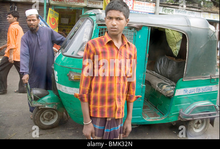 Scène de rue, debout devant les hommes musulmans de tempo vert auto rickshaw ; à côté Sadarghat ; terminal de bateaux ; Bangladesh Dhaka Banque D'Images