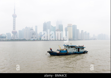 Petit bateau l'écopage les détritus sur la rivière Huangpu, Shanghai, Chine Banque D'Images