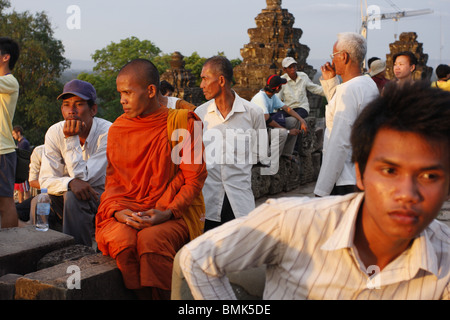 Un jeune homme cambodgien jouit de la vue du coucher de soleil au large de Wat Phnom Bakeng à Angkor, Cambodge Banque D'Images