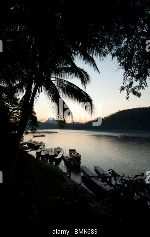 Les soleils se couche derrière les montagnes sur le Mékong à Luang Prabang au Laos Banque D'Images