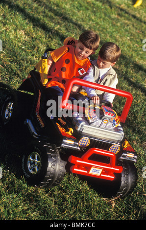 2, 3, 4, 5, garçons plus dur petit enfant's off road Jeep style in backyard Banque D'Images