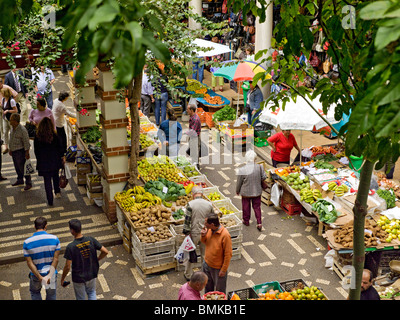 Les gens qui achètent des fruits et légumes frais sur des étals du Marché Agricole Mercado dos Lavradores Funchal Madère Portugal Europe de l'UE Banque D'Images