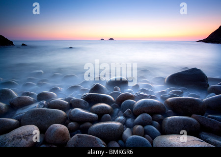 Des rochers sur la plage au coucher du soleil Cornwall Banque D'Images