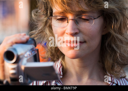 Une jeune femme souriante, l'enregistrement vidéo numérique, caméra en main, Rome, Italie Banque D'Images
