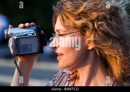 Une jeune femme souriante, l'enregistrement vidéo numérique, caméra en main, Rome, Italie Banque D'Images