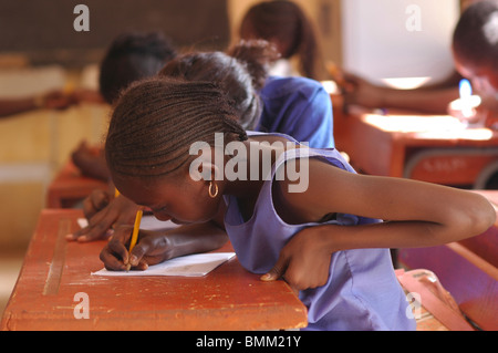 Le Niger, Niamey, élèves africains assis à leur bureau en bois dans la salle de classe. Banque D'Images