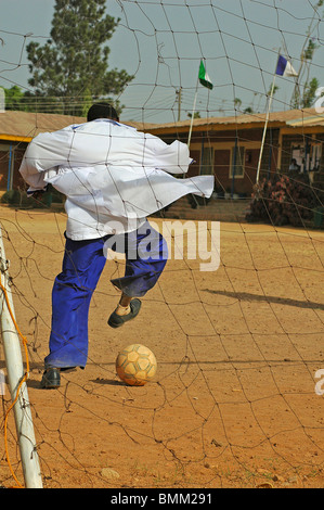 Le Nigéria, Jos, dans son uniforme d'écolier, jouer au football. Banque D'Images