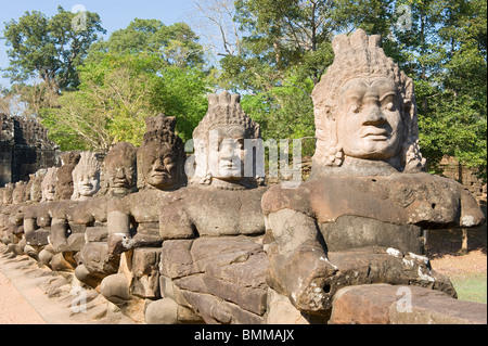 Les pierres de dieux guerriers près de la porte de la victoire et l'entrée sud d'Angkor Thom au Cambodge Banque D'Images