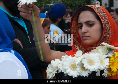 Jeune femme sikh remet des fleurs pour être portées en hommage aux morts en 1984 massacres indiens. Londres, Royaume-Uni. 13/06/2010 Banque D'Images