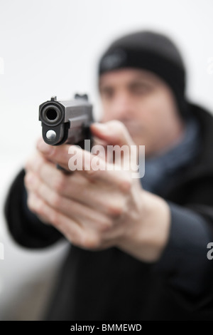 Homme pointant une arme de poing chargée Banque D'Images